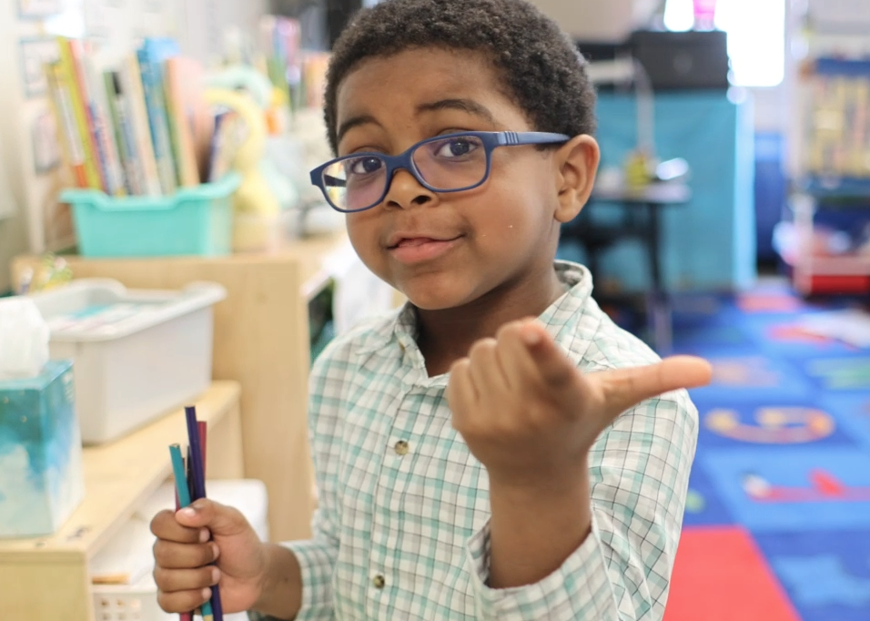 young boy pointing at the camera