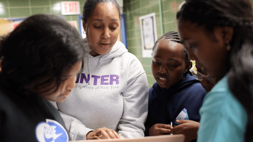 teacher looking at screen with students
